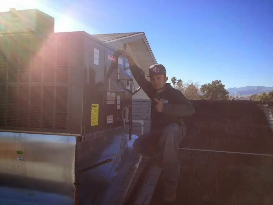 HVAC technician performing AC Tune-Up on a rooftop unit in Fountainhead-Orchard Hills